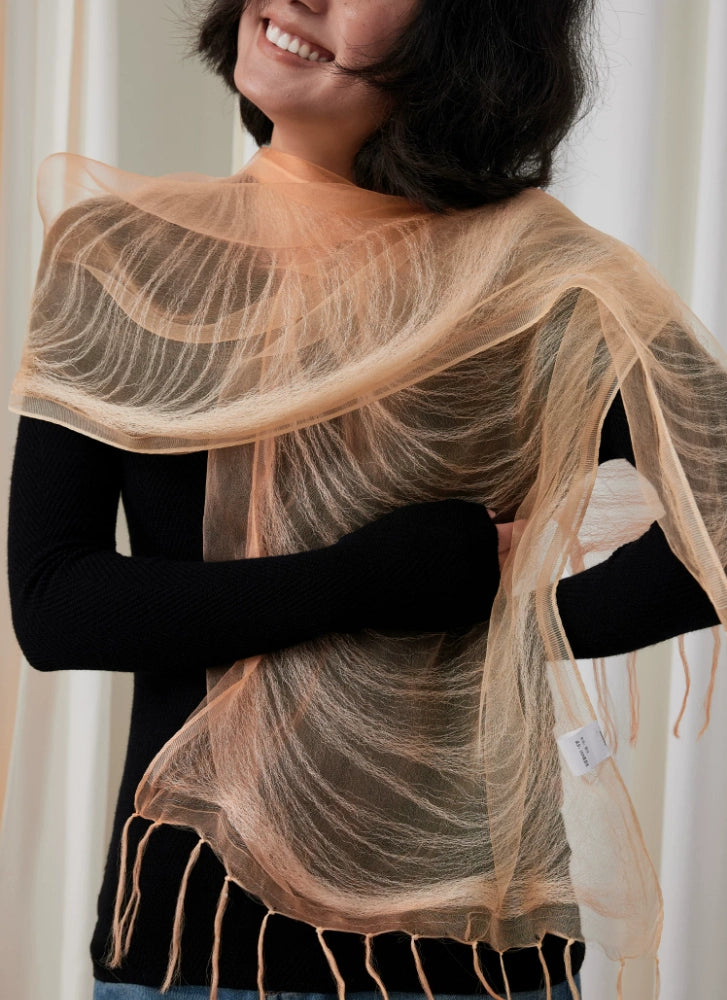 Sheer sweet orange silk fringe scarf draped elegantly across the shoulders
