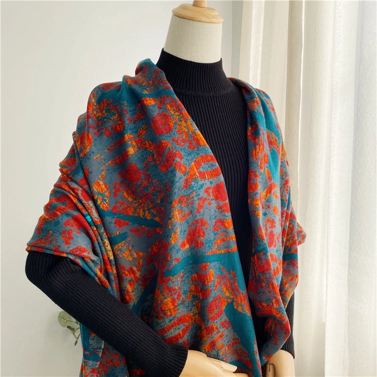 Oversized teal peacock print wool scarf draped as a shoulder wrap over a black outfit