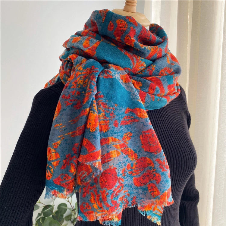 Teal and red peacock wool scarf wrapped around the neck with long fringed ends