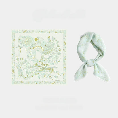 Tender green 65 cm mulberry silk square scarf with vintage elephant and floral print, shown flat and tied