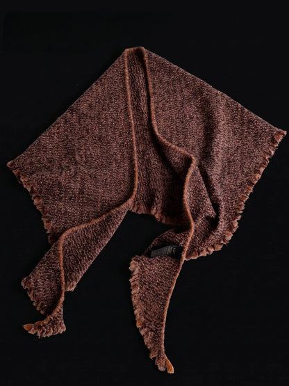 Terracotta cashmere triangle scarf laid out to show its triangular shape, textured knit and fringed edges.