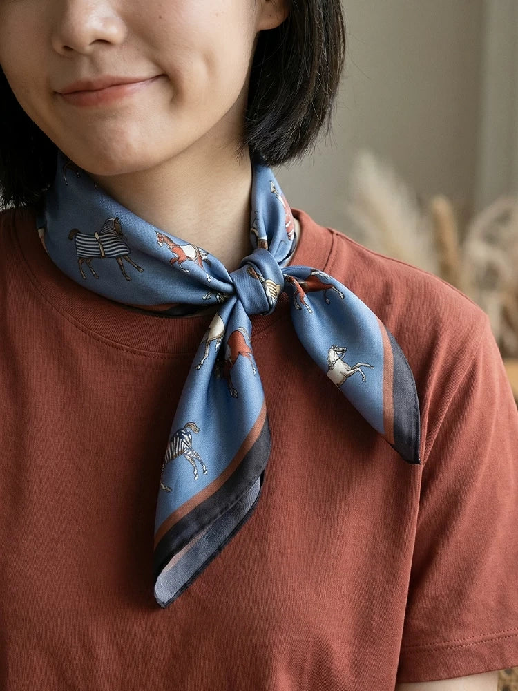 Close-up of a 12 momme mulberry silk horse print scarf styled in a classic neck knot