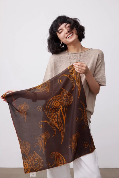 Brown goldfinch mulberry silk square scarf styled as a lightweight shoulder wrap with an elegant vintage look.