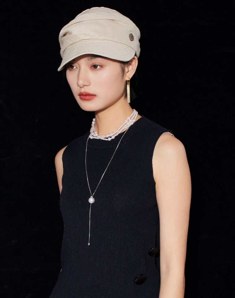Model wearing cream white vintage beret hat for women with minimalist black outfit