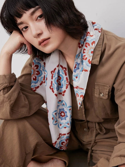 Model wearing a vintage blue floral silk foulard in 100% mulberry silk for refined everyday styling.