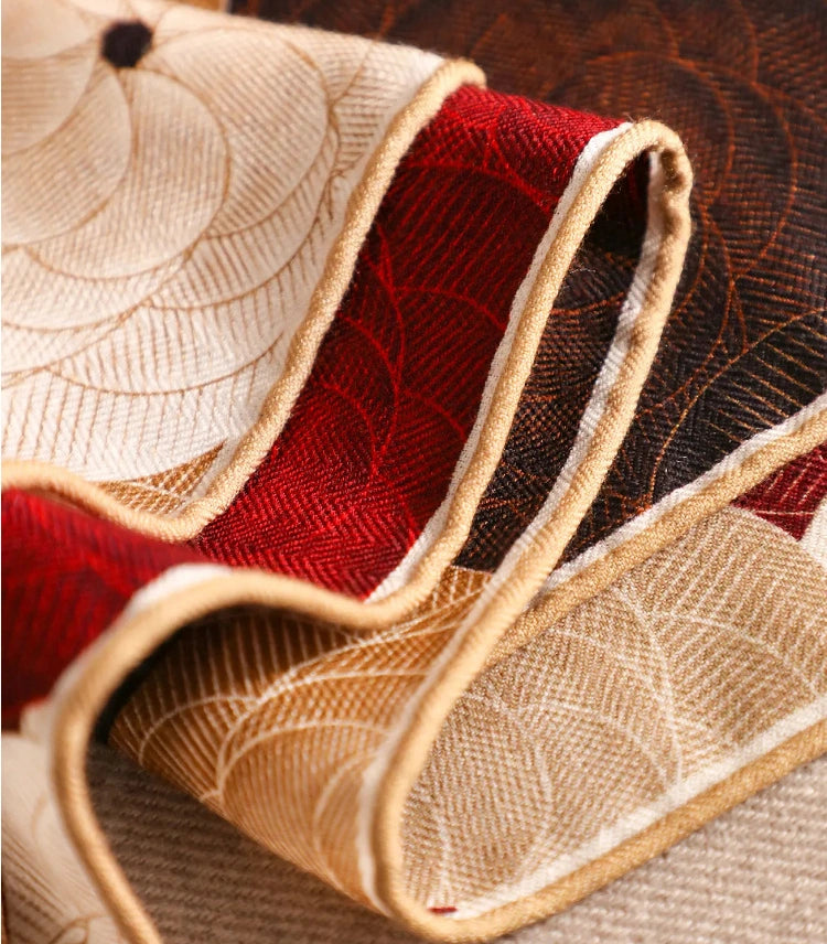 Folded silk wool square scarf showing soft texture, floral print and burgundy reverse side.