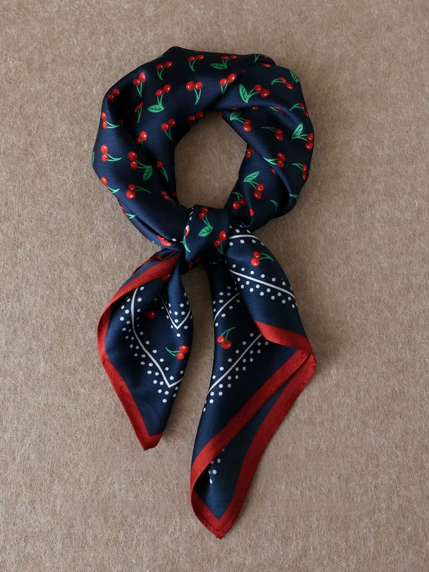 Vintage navy cherry silk square scarf tied in a neat knot with contrasting red trim