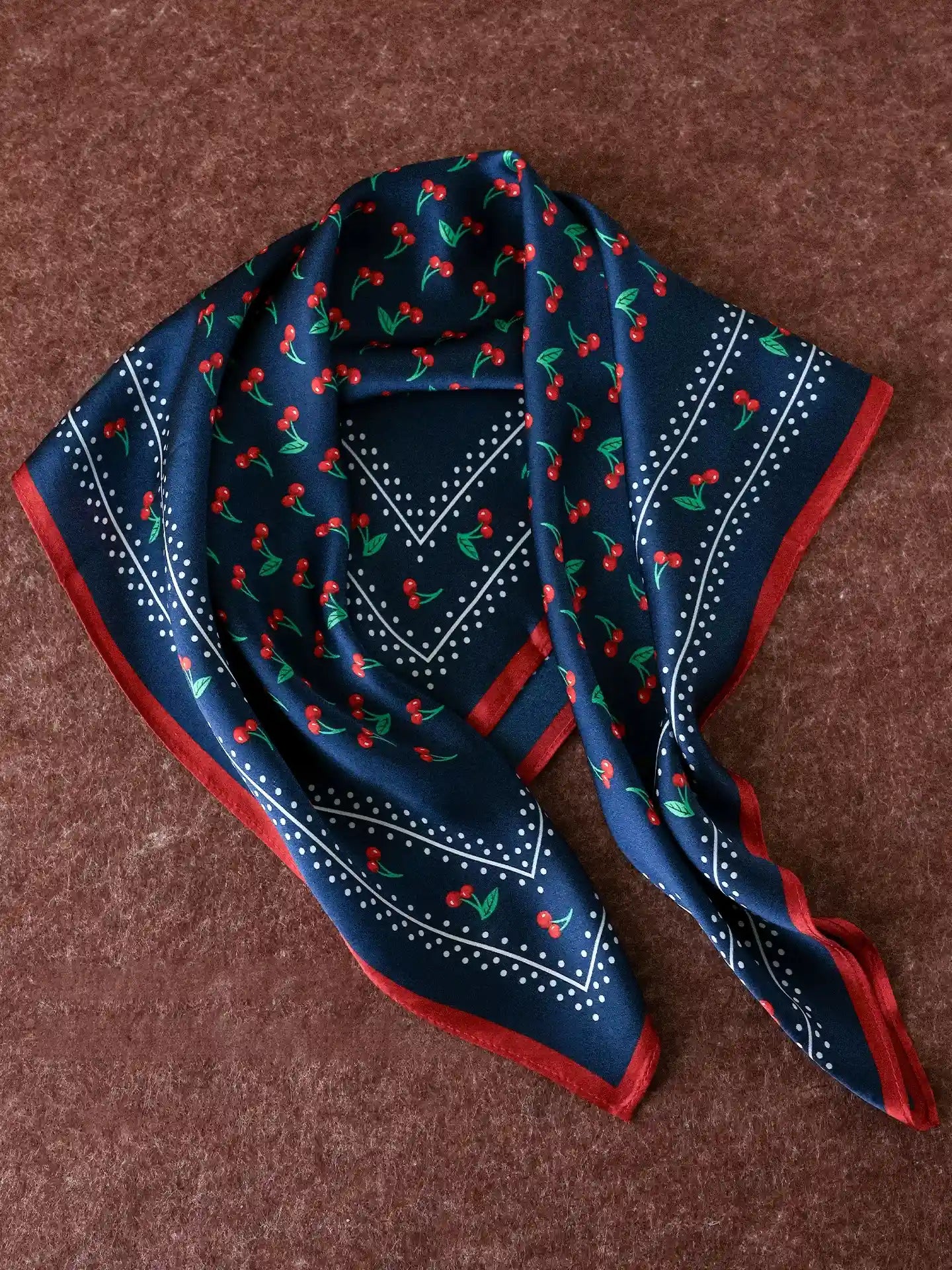Navy mulberry silk scarf with red cherry print, dotted details, and a contrasting border