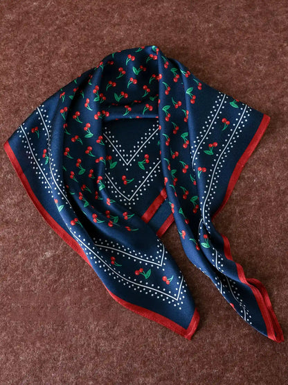 Navy mulberry silk scarf with red cherry print, dotted details, and a contrasting border