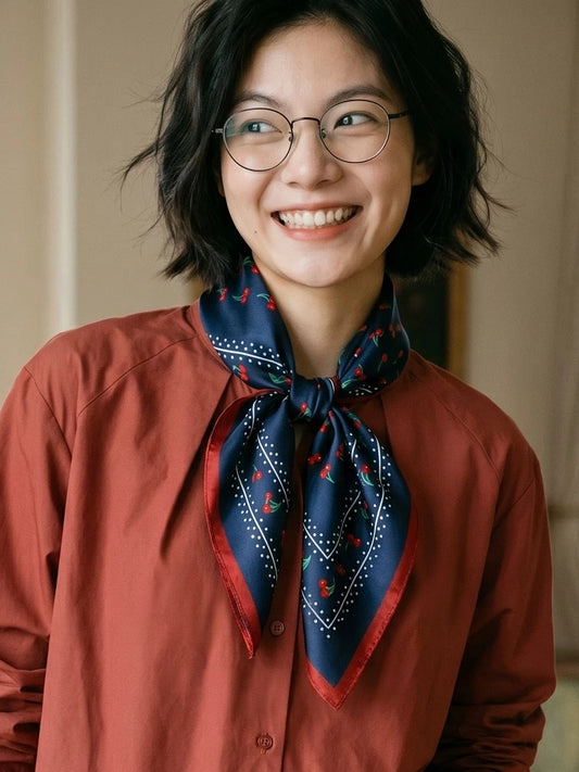 Model wearing a vintage navy cherry mulberry silk scarf with a rust-colored shirt