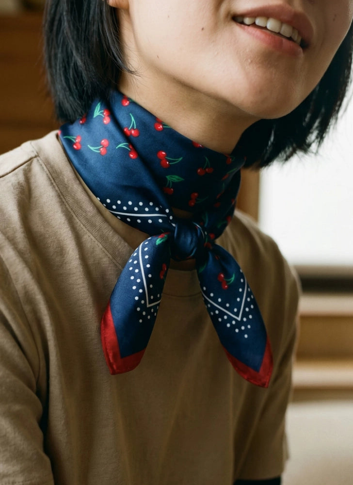 Vintage navy cherry silk square scarf tied at the neck with a soft brown top