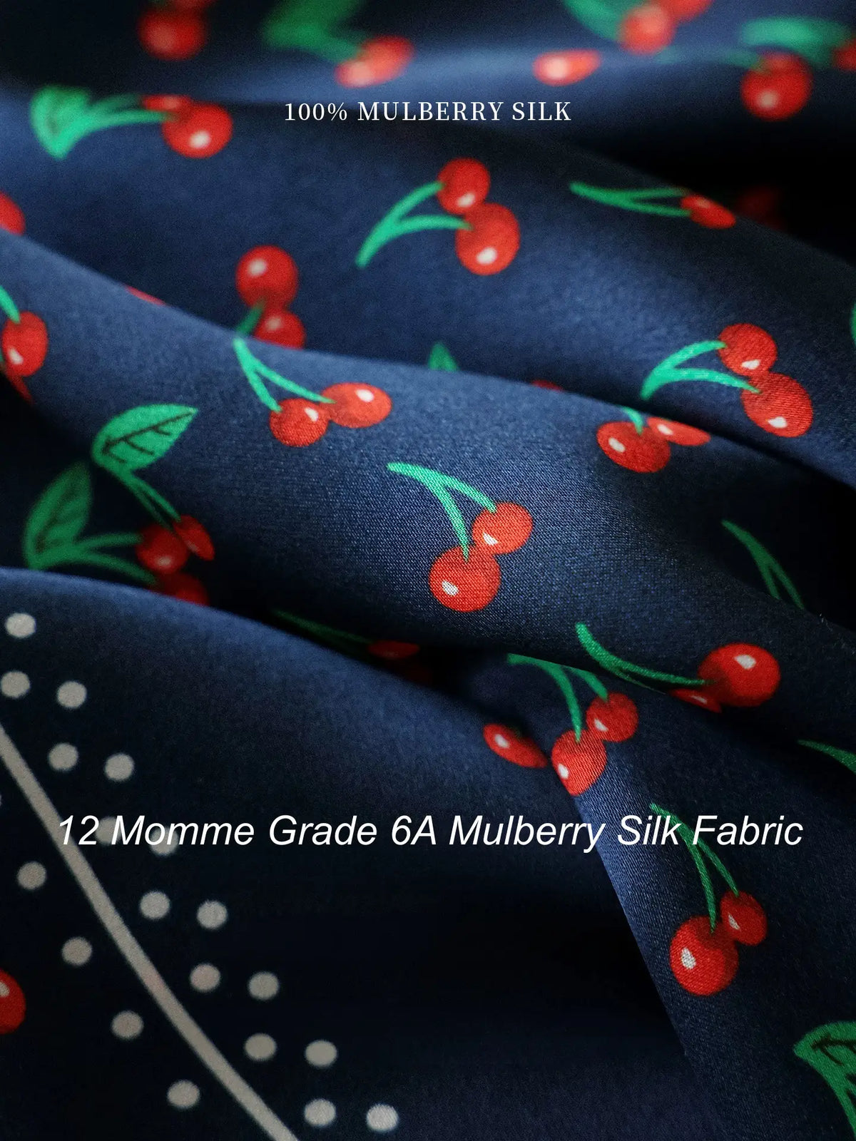 Close-up of 12 momme Grade 6A mulberry silk fabric with red cherry print on navy blue
