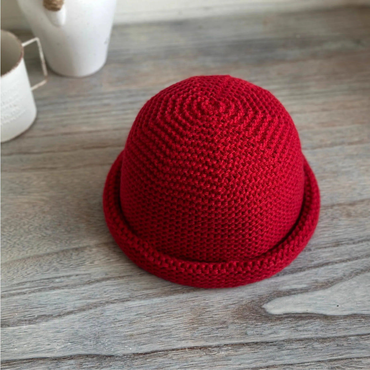 Top-front view of a vintage red wool blend knit hat showing spiral crown stitching and rolled edge