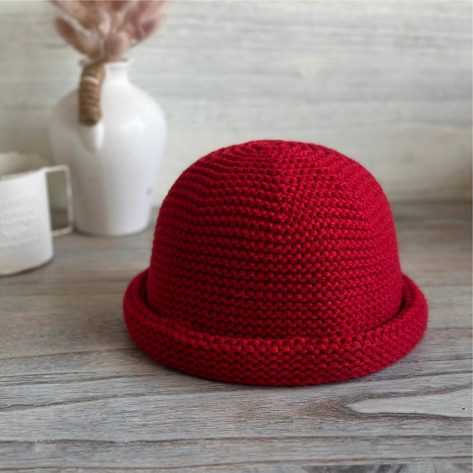 Front view of a vintage red wool blend dome beanie with textured knit and a compact rolled brim