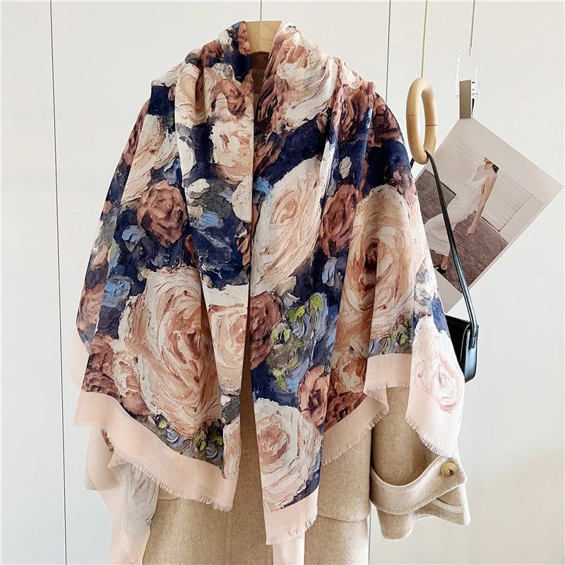 Oversized rose floral wool shawl spread across the shoulders of a beige coat for full coverage