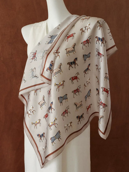 Vintage white equestrian silk square scarf draped over a mannequin shoulder