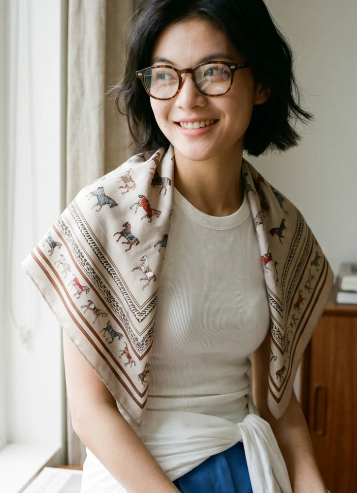 Woman wearing a vintage white horse print silk scarf draped over the shoulders