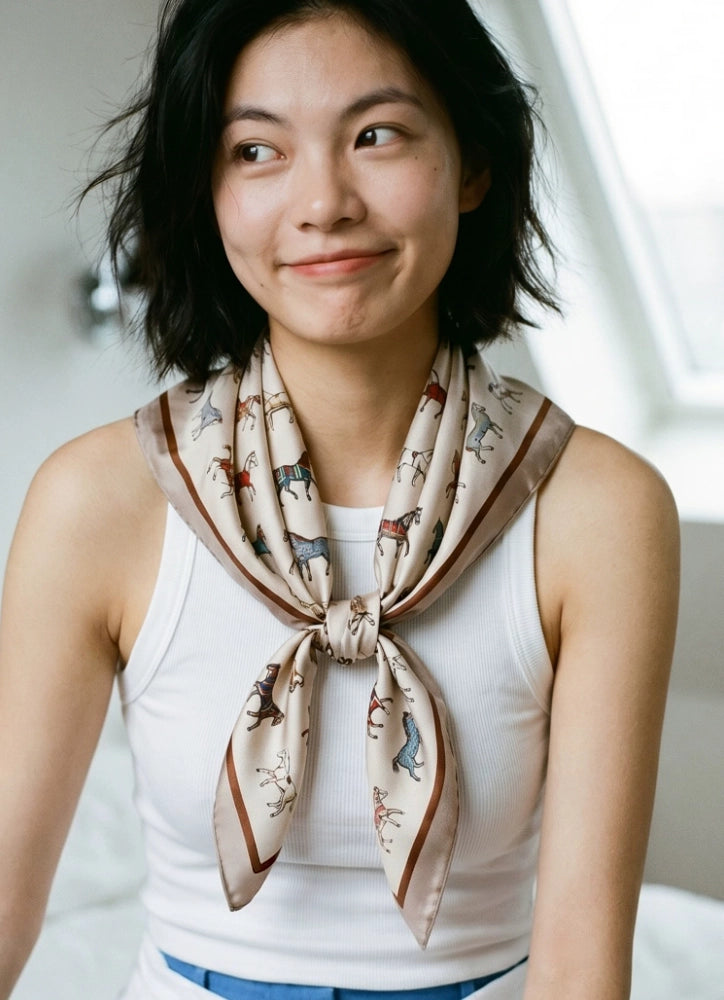 Woman styling a vintage white mulberry silk horse scarf in a relaxed front knot