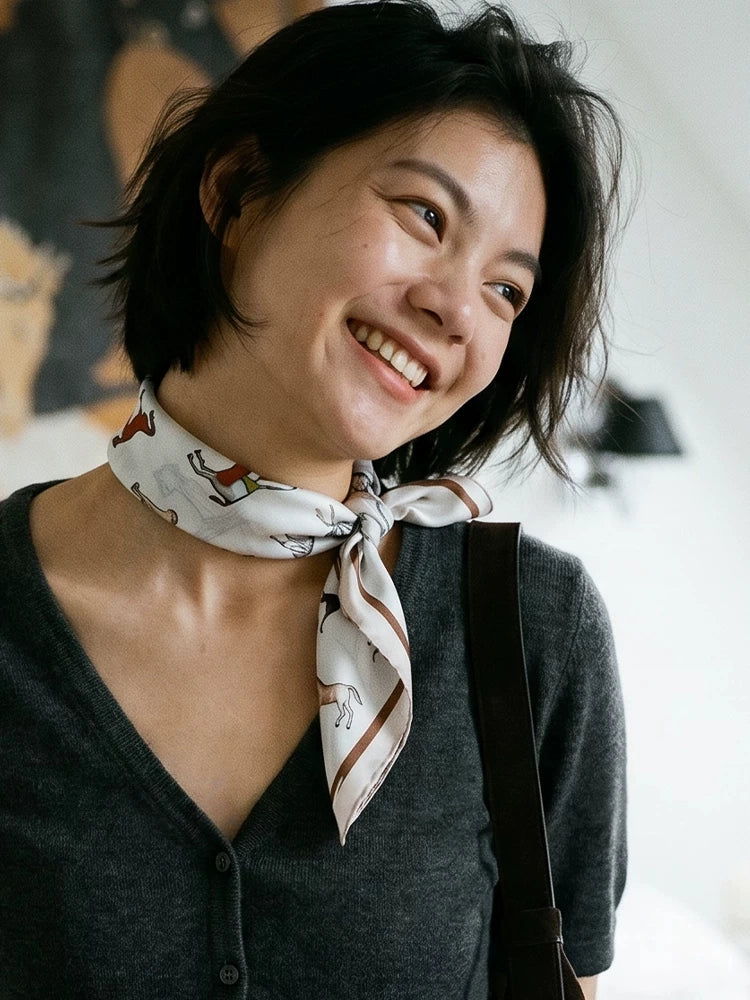 Vintage white equestrian silk neckerchief paired with a dark V-neck cardigan