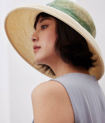 Woman wearing vintage white wide brim sun hat for resort and summer travel.