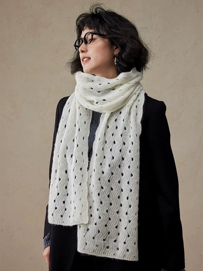 Cream white cashmere scarf looped around the neck, with both ends hanging down the front of a black coat.