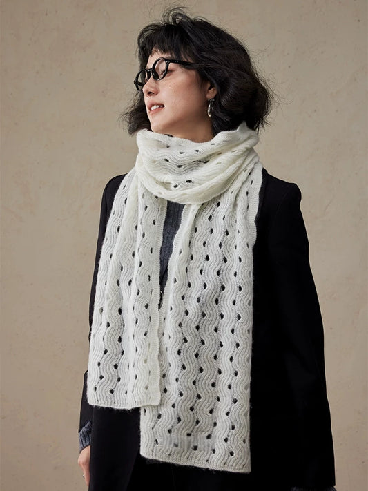 Cream white cashmere scarf looped around the neck, with both ends hanging down the front of a black coat.