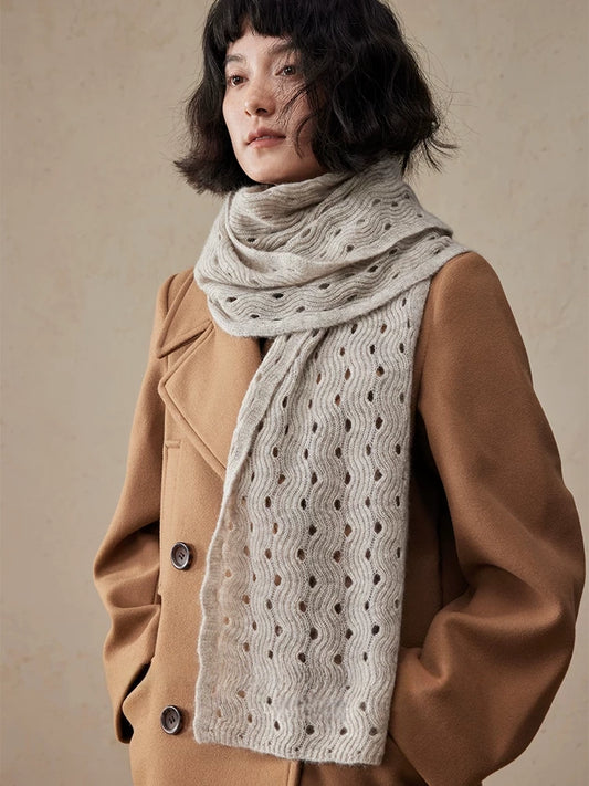 Light khaki cashmere scarf wrapped around the neck, with a long end hanging down the front of a camel coat.