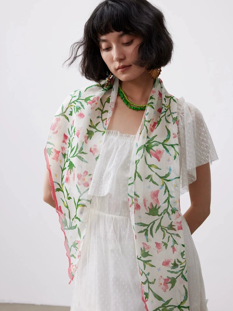 Model wearing a white morning glory skinny silk scarf with a soft summer dress