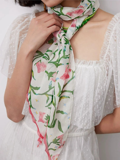 White morning glory skinny silk scarf tied around the neck as a delicate accessory