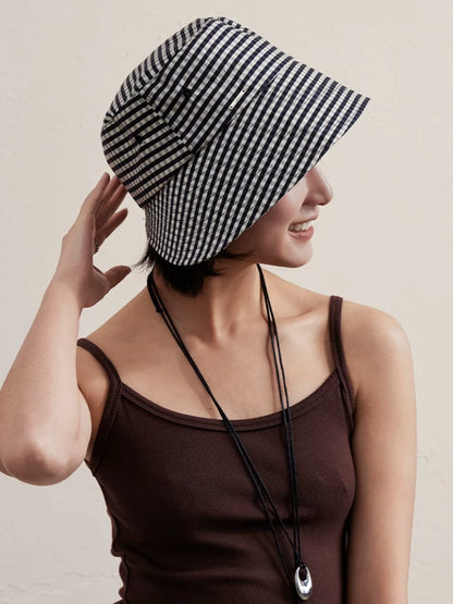 Woman wearing a black and white plaid wide brim bucket hat in casual summer style