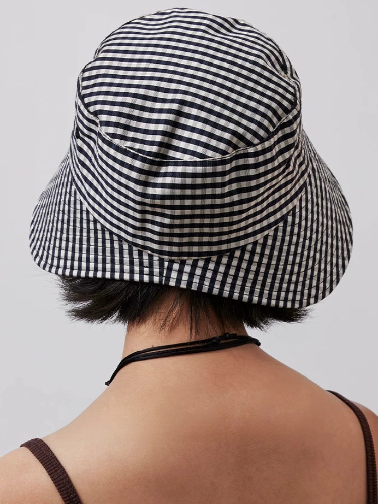 Rear view of women's black and white plaid open back bucket hat for low ponytails