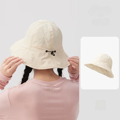 Rear view of a woman wearing an ivory wide brim bucket hat, showing the black drawstring adjuster.