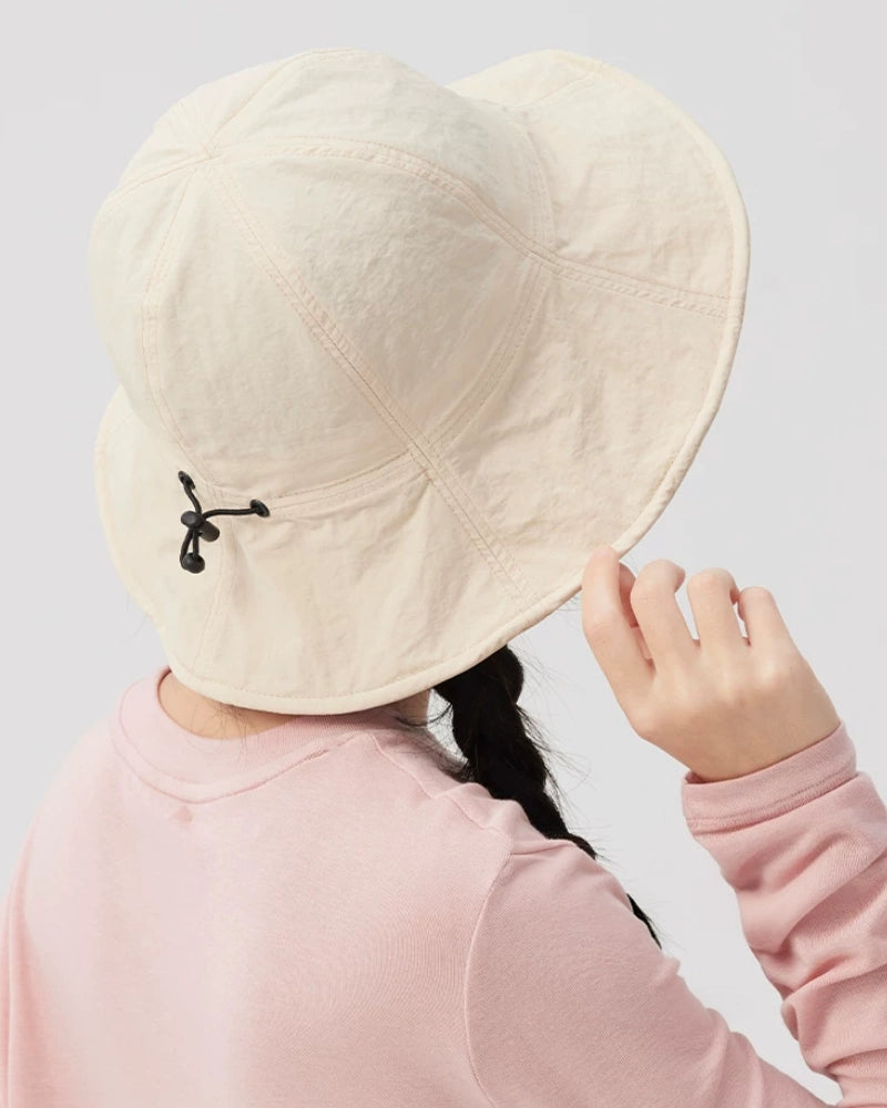 Angled rear view of an ivory bucket hat showing the rounded crown, upturned brim and rear drawstring.