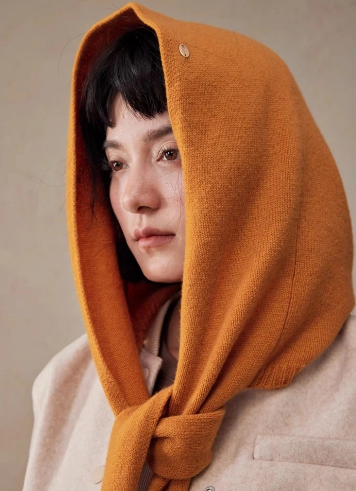 Close-up of woman wearing a burnt orange wool hooded scarf with hood up
