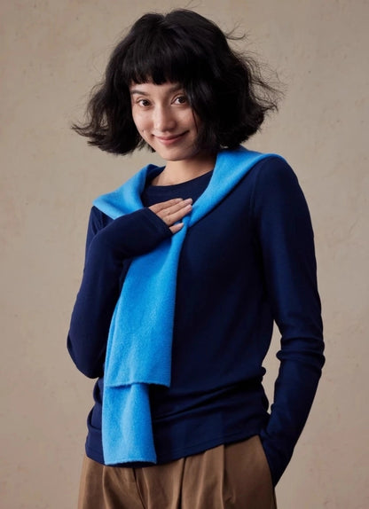 Woman styling a royal blue wool hooded scarf draped around the neck over a navy sweater