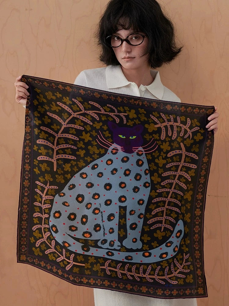 Woman holding an open woodland brown leopard floral mulberry silk scarf with plum and olive details