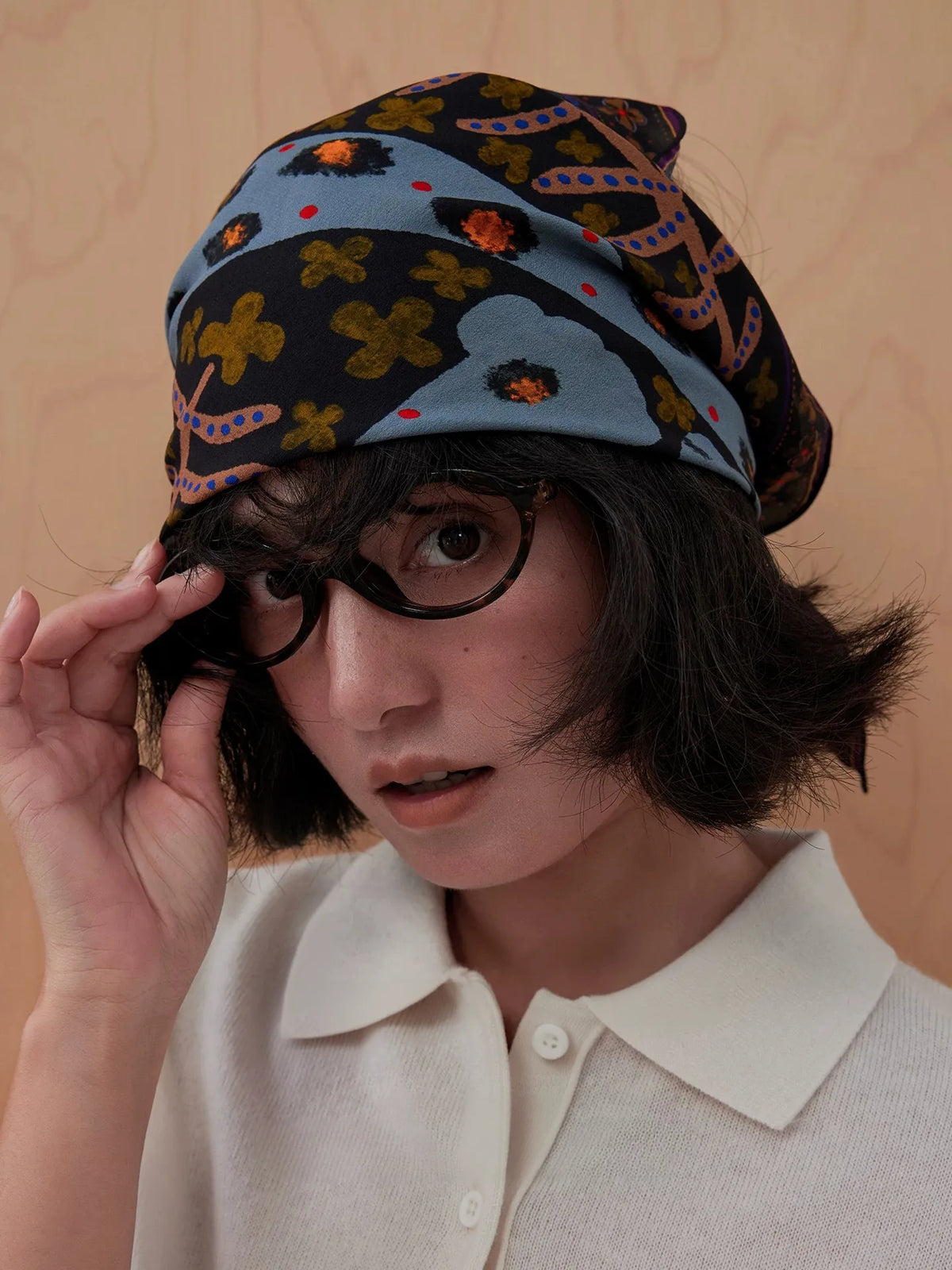 Woman wearing a woodland brown and plum leopard silk square scarf as a retro headscarf
