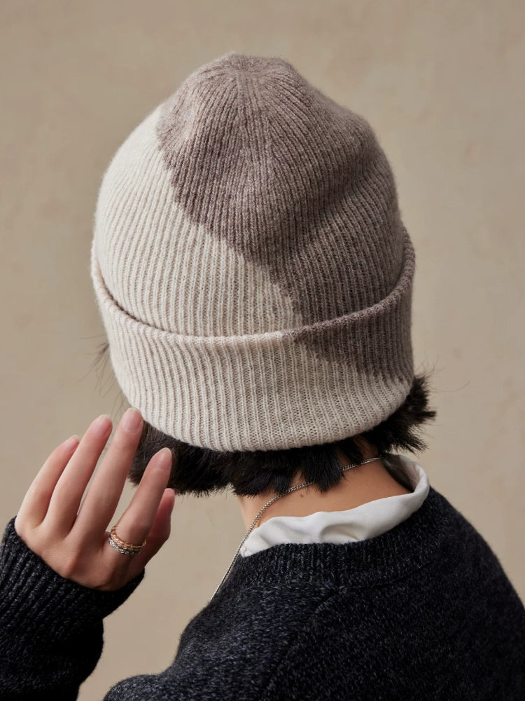Back view of a beige taupe two-tone wool beanie worn by a model, showing the contrasting crown, ribbing and folded cuff.