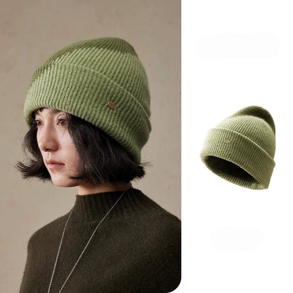 Moss green wool color block beanie shown on a model and as a standalone hat, with diagonal contrast and a ribbed cuff.
