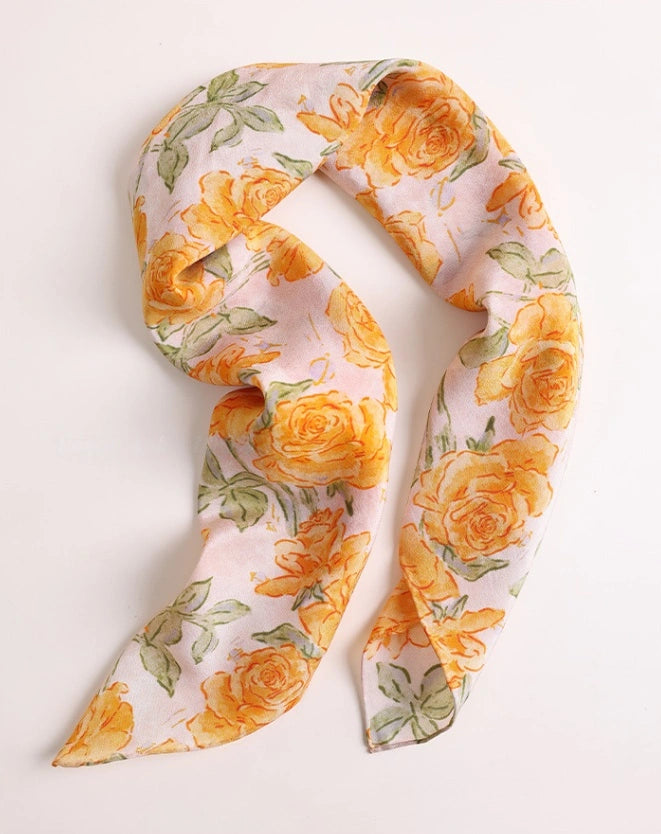 Elegant yellow rose-print silk square scarf, showcasing its silky texture and timeless design.