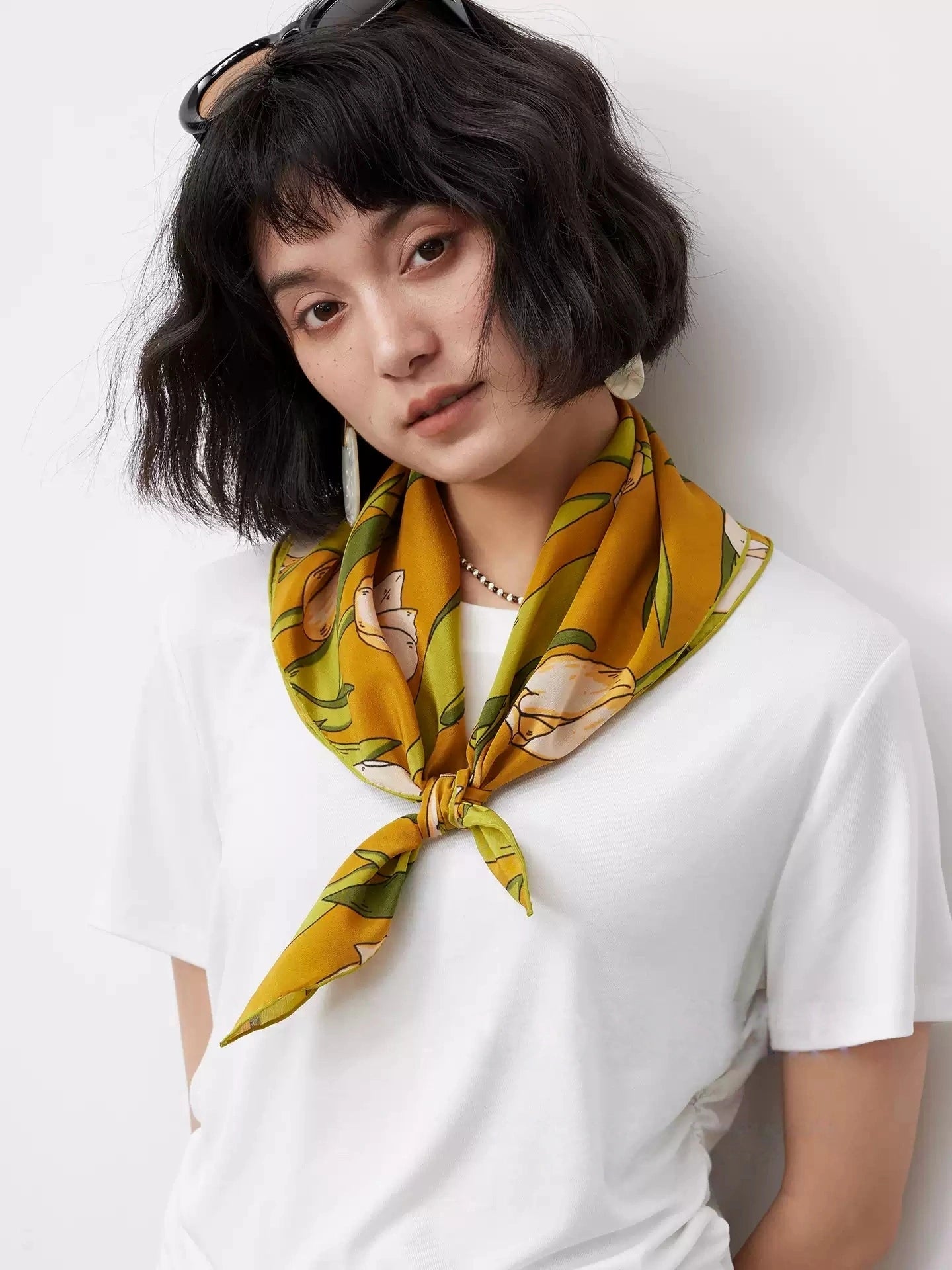A yellow tulip floral print silk square scarf made from 100% mulberry silk is displayed as a neck scarf.